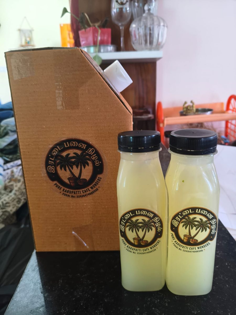 Irattai Panai Nizhal branded cardboard delivery box with logo sticker and two lime juice bottles